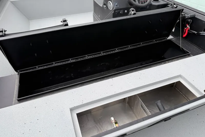 Slide: The Image of 2026 SeaArk Shadow 20 boat interior storage compartments, showcasing open lids and sleek design. - 11