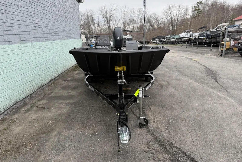 Slide: The Image of 2026 SeaArk Shadow 20 boat on trailer, parked outdoors near a brick wall. - 3