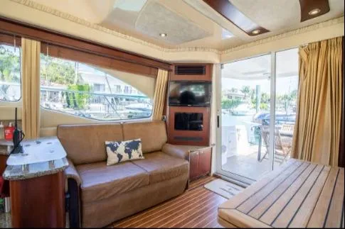 Slide: The Image of Interior of 2005 Sea Ray 420 Sedan Bridge yacht with sofa and large windows. - 11