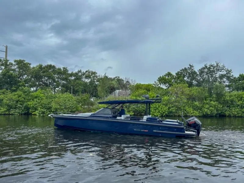 Slide: The Image of 2024 BRABUS Shadow 1000 ST luxury boat on a calm river with lush greenery. - 6