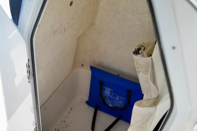 Slide: The Image of Storage compartment inside 2020 Key West 203 FS boat with blue bag and tools. - 14