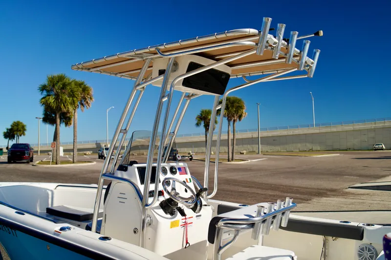 Slide: The Image of 2020 Key West 203 FS boat with T-top, parked near palm trees under clear blue sky. - 8