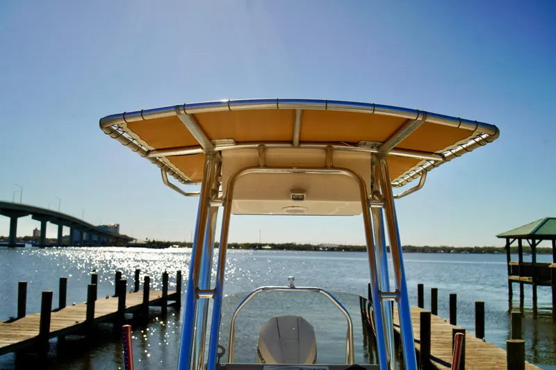 Slide: The Image of 2020 Key West 203 FS boat docked by a scenic waterfront with a bridge view. - 9