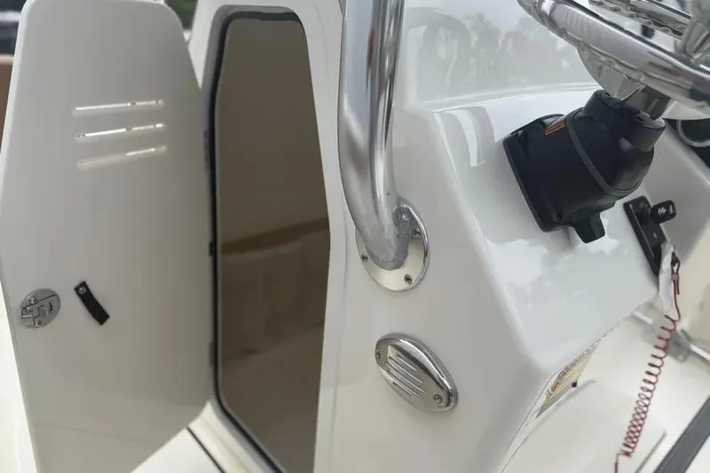 Slide: The Image of 2026 Pioneer 202 Islander boat console with open storage compartment and steering wheel. - 9