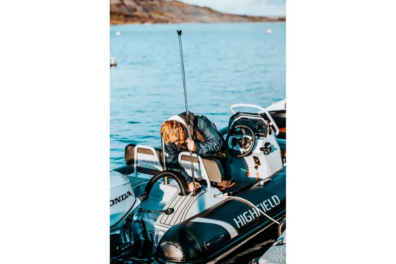 Slide: The Image of 2026 Highfield Sport 460 boat on water with person adjusting equipment. - 5