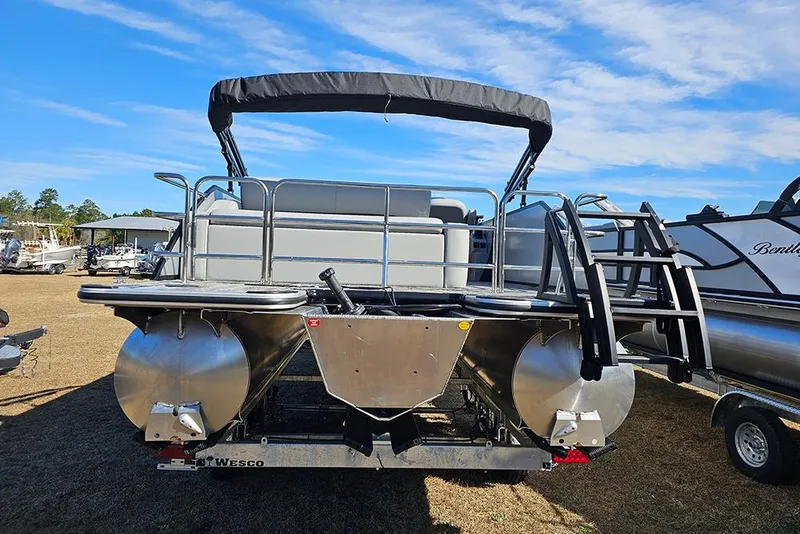 Slide: The Image of 2026 Bentley Pontoons Legacy 243 Swingback, rear view, on trailer, under clear blue sky. - 6