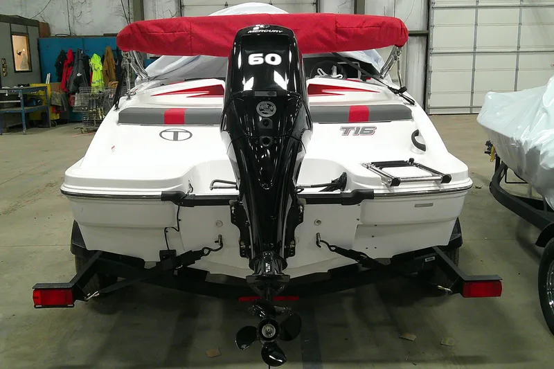 Slide: The Image of 2024 Tahoe T16 boat with outboard motor in a garage setting. - 12