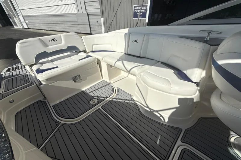 Slide: The Image of 2013 Monterey 264FS boat interior with white seating and gray flooring. - 13