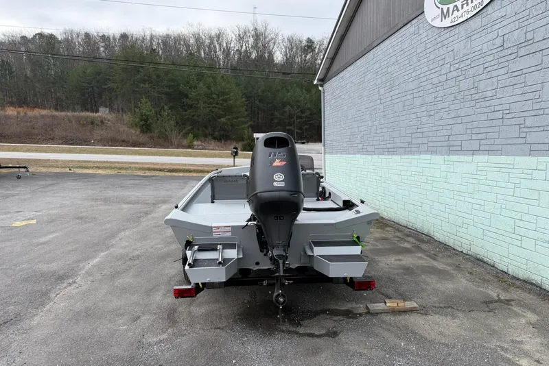 Slide: The Image of 2026 SeaArk Shadow 187 boat with outboard motor, parked beside a building. - 7