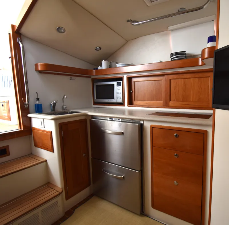 Slide: The Image of 2011 MJM 40z Downeast yacht kitchen with stainless steel appliances and wooden cabinets. - 22