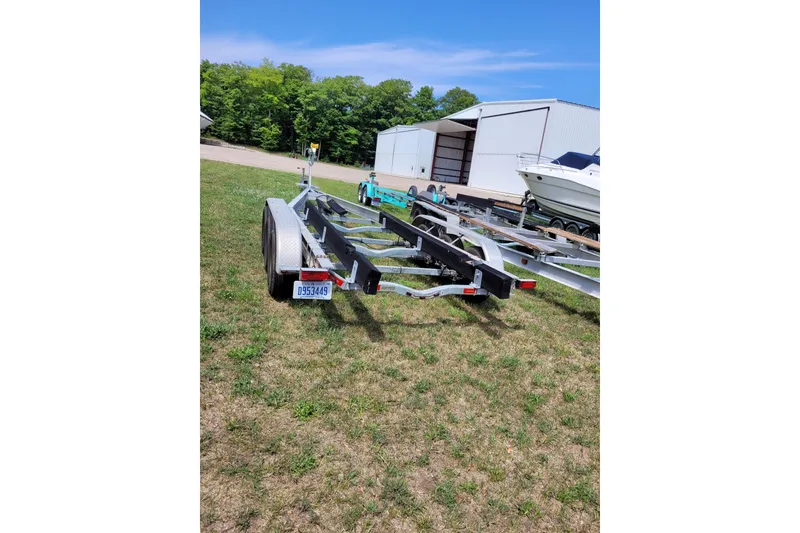 Slide: The Image of Trailer for 2005 Chaparral Signature 310 boat parked on grass near a warehouse. - 18