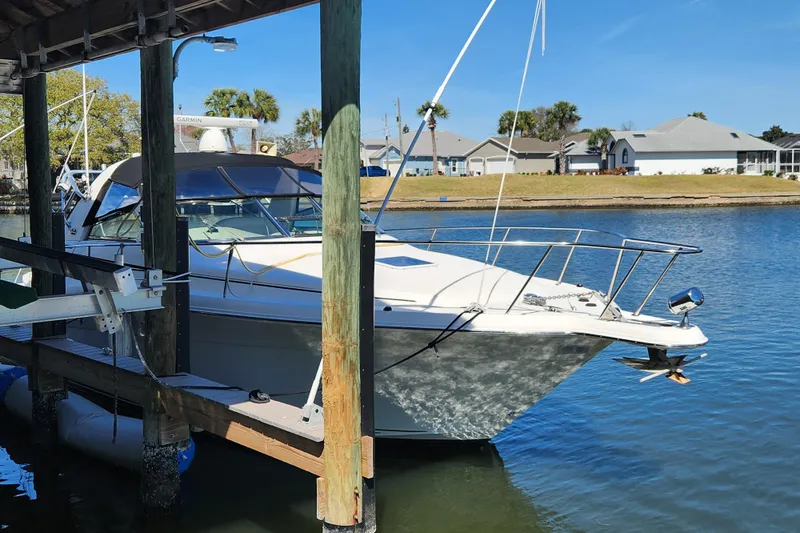 Slide: The Image of 2001 Sea Ray 340 Amberjack docked in a serene marina setting. - 1