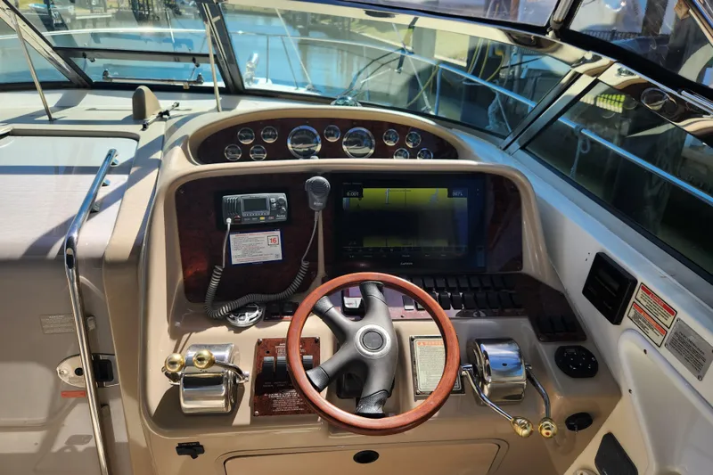 Slide: The Image of Helm of 2001 Sea Ray 340 Amberjack with steering wheel and navigation controls. - 14