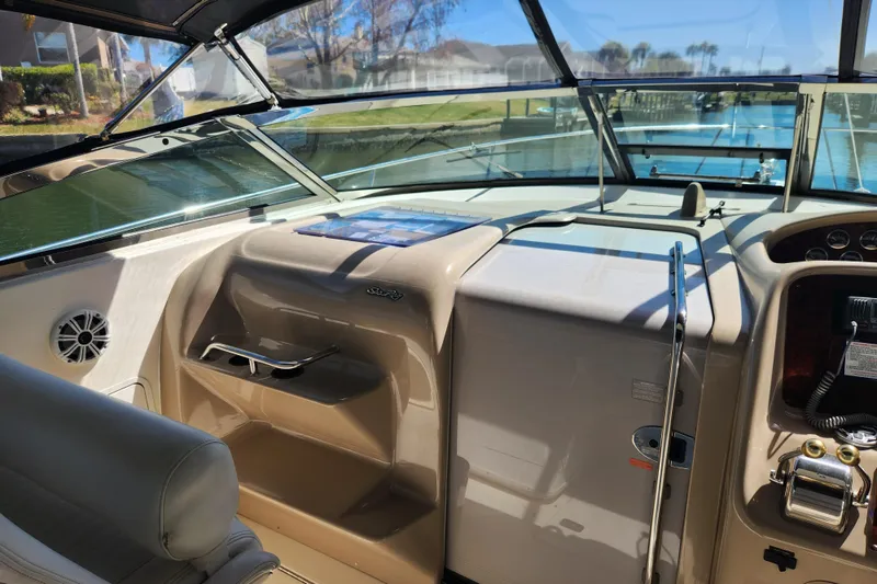 Slide: The Image of 2001 Sea Ray 340 Amberjack helm with steering wheel and control panel, docked by a canal. - 17
