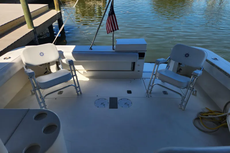 Slide: The Image of 2001 Sea Ray 340 Amberjack boat deck with chairs and American flag. - 19