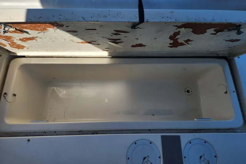 Slide: The Image of Open storage compartment on 2001 Sea Ray 340 Amberjack boat, showing wear and tear. - 26