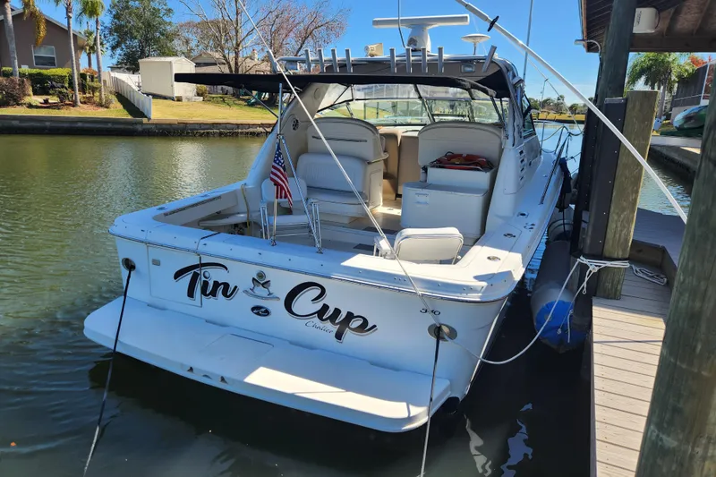 Slide: The Image of 2001 Sea Ray 340 Amberjack boat docked, featuring spacious deck and American flag. - 3