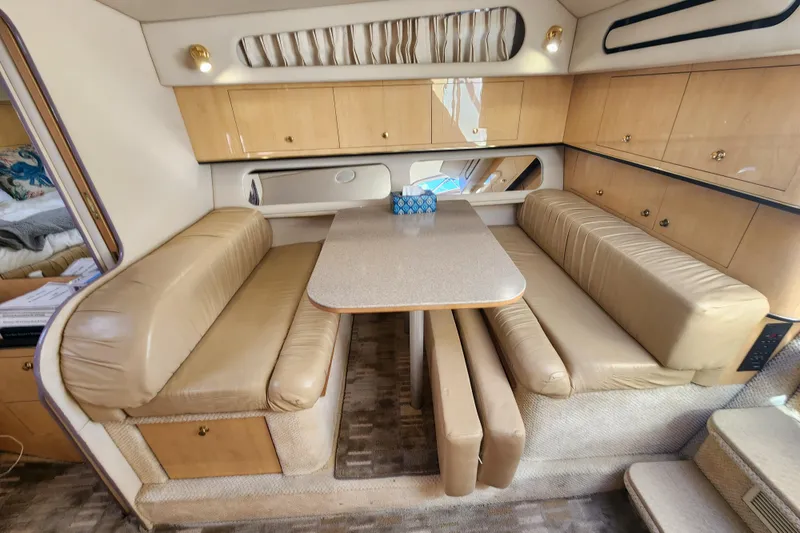 Slide: The Image of 2001 Sea Ray 340 Amberjack cabin with beige seating and dining table. - 35