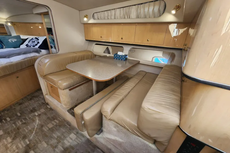 Slide: The Image of 2001 Sea Ray 340 Amberjack cabin interior with beige seating and dining area. - 36