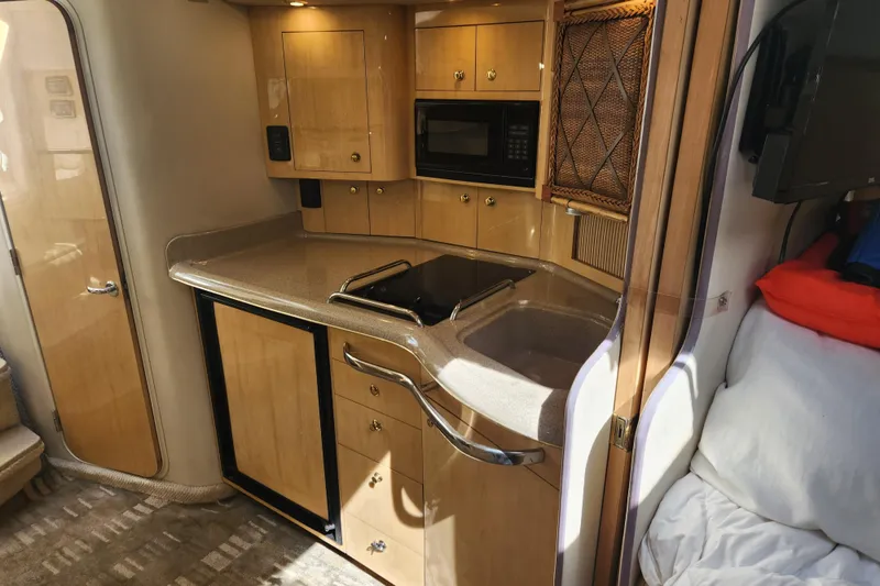 Slide: The Image of 2001 Sea Ray 340 Amberjack interior kitchen with wooden cabinets and modern appliances. - 37