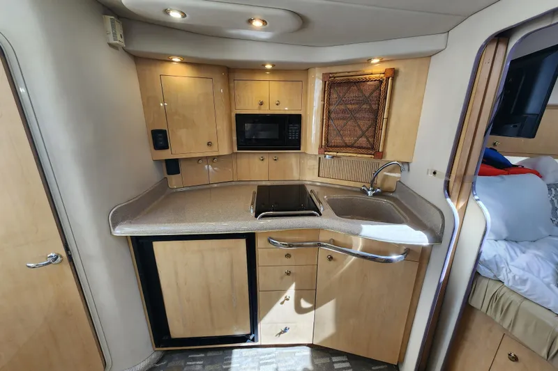 Slide: The Image of 2001 Sea Ray 340 Amberjack interior kitchen with wood cabinets, sink, and microwave. - 38