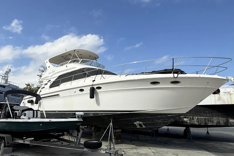 The Image of 2001 Sea Ray 560 Sedan Bridge yacht on dry dock under a clear blue sky. - 0