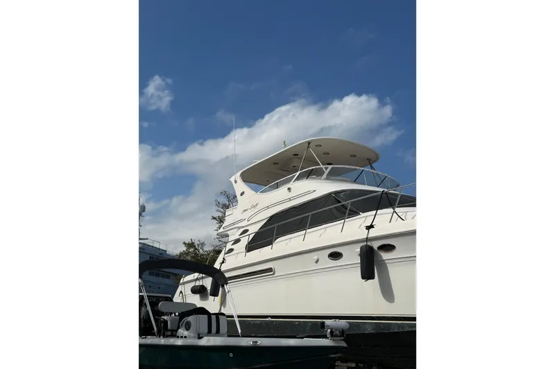 Slide: The Image of 2001 Sea Ray 560 Sedan Bridge yacht under a clear blue sky. - 3