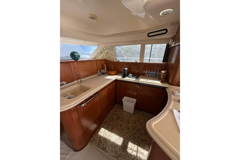 Slide: The Image of Luxurious kitchen interior of 2001 Sea Ray 560 Sedan Bridge yacht with wooden cabinetry. - 52