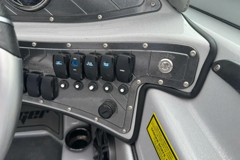 Slide: The Image of Control panel of 2024 Sanger 215 S boat with various switches and buttons. - 11