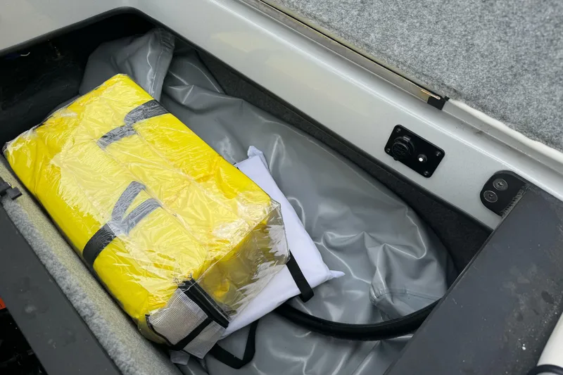 Slide: The Image of Storage compartment in 2024 Sanger 215 S boat with yellow life jacket. - 18