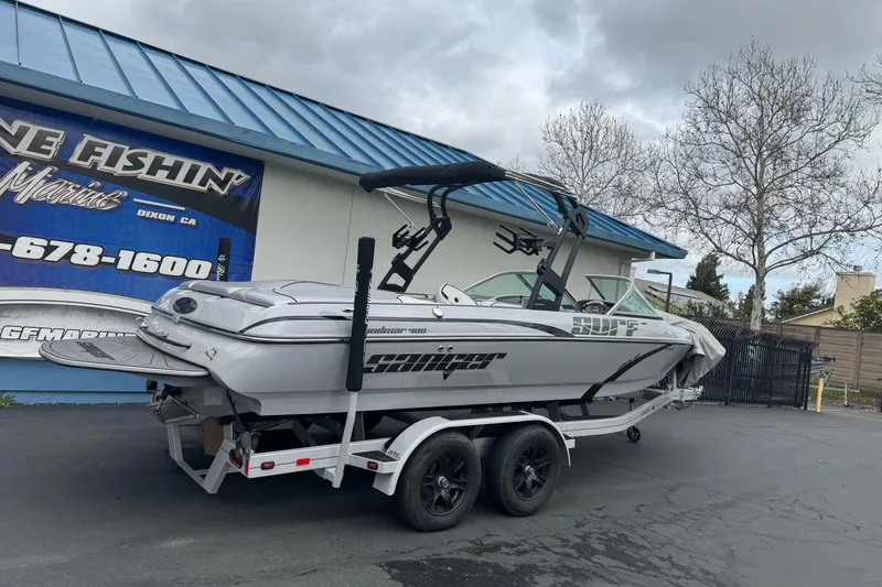 Slide: The Image of 2024 Sanger 215 S boat on trailer outside a marine dealership. - 2
