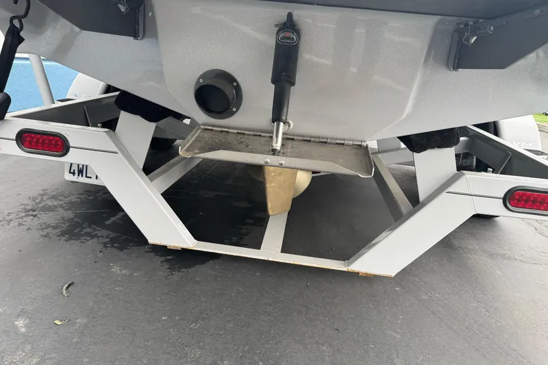 Slide: The Image of Rear view of 2024 Sanger 215 S boat on trailer, showcasing propeller and trim tab. - 22