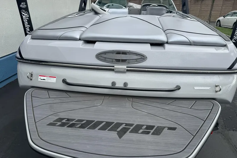 Slide: The Image of 2024 Sanger 215 S boat rear view with branded swim platform and sleek design. - 4