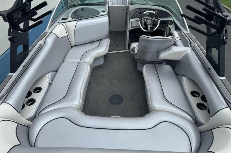 Slide: The Image of 2024 Sanger 215 S boat interior with sleek gray seating and modern dashboard. - 8