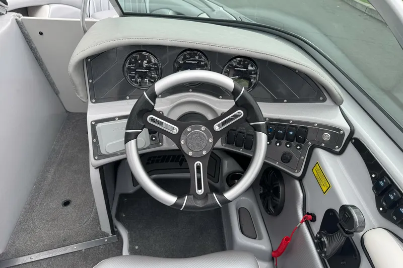 Slide: The Image of 2024 Sanger 215 S boat dashboard with steering wheel and instrument panel. - 9