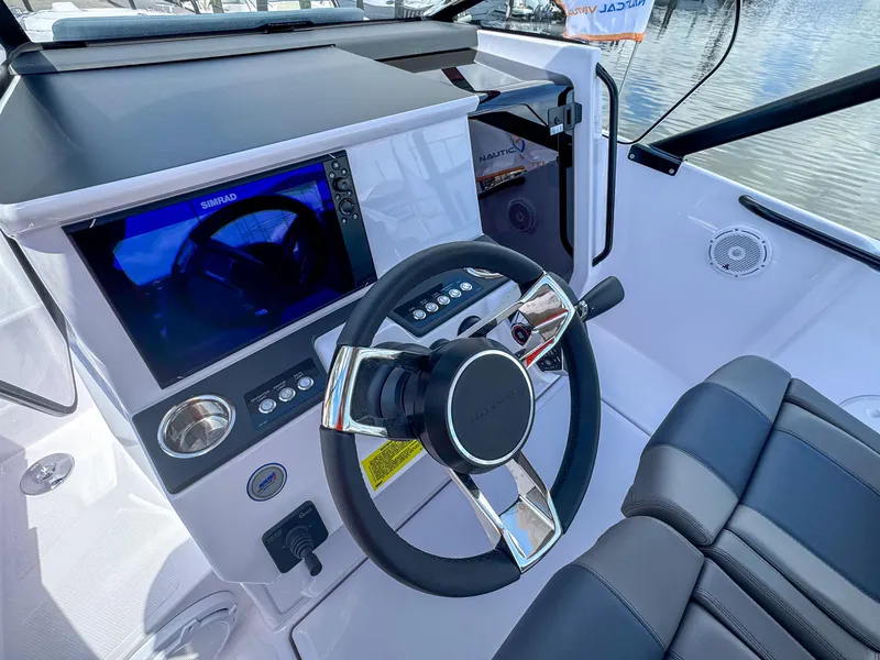 Slide: The Image of 2025 Axopar 25 Cross Top boat cockpit with steering wheel and navigation display. - 3