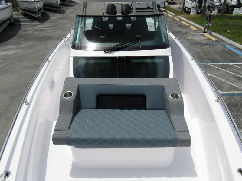 Slide: The Image of 2024 Axopar 37 Sun Top boat with cushioned seating and sleek windshield design. - 11