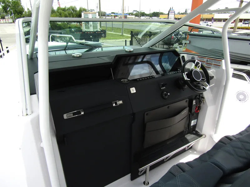 Slide: The Image of 2024 Axopar 37 Sun Top boat cockpit with modern steering and dashboard controls. - 16