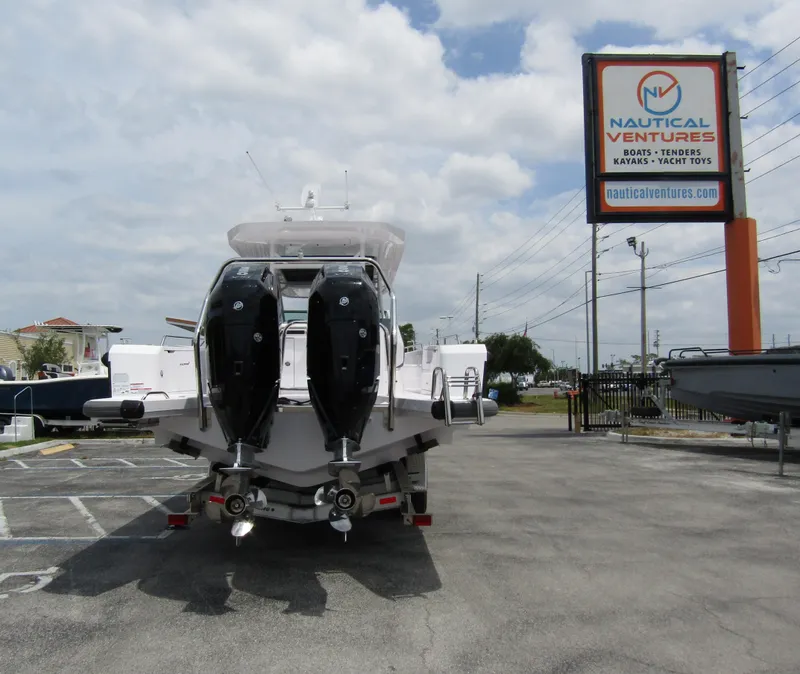Slide: The Image of 2024 Axopar 37 Sun Top boat at Nautical Ventures dealership, rear view. - 2