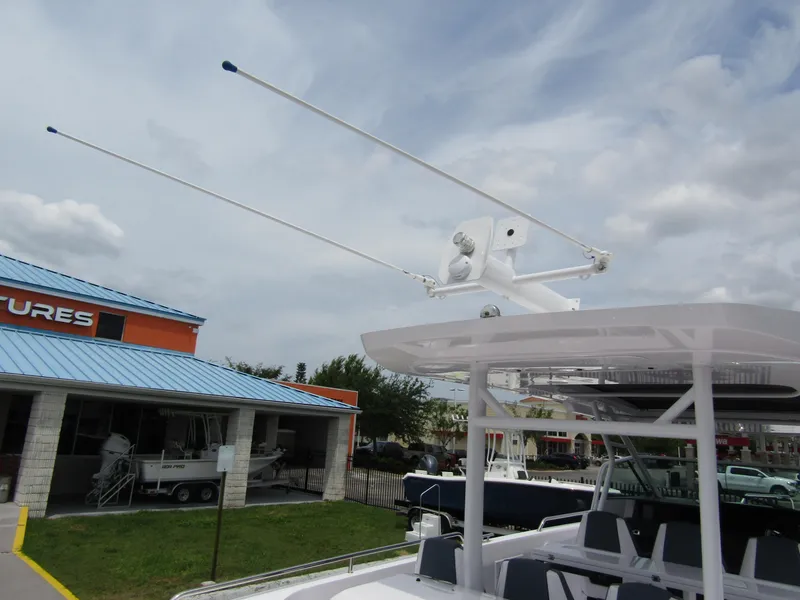 Slide: The Image of 2024 Axopar 37 Sun Top boat with radar and antennas, docked near a building. - 34