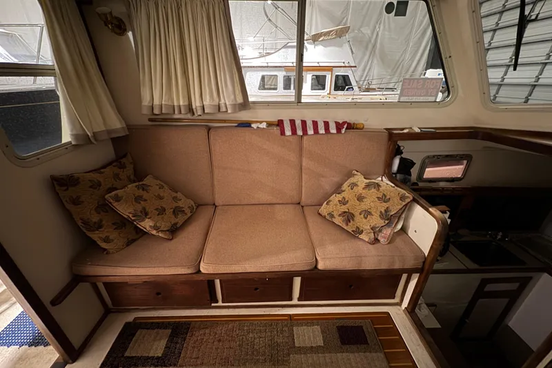 Slide: The Image of Interior of 1988 Blue Seas 31 boat with cozy seating and decorative pillows. - 11