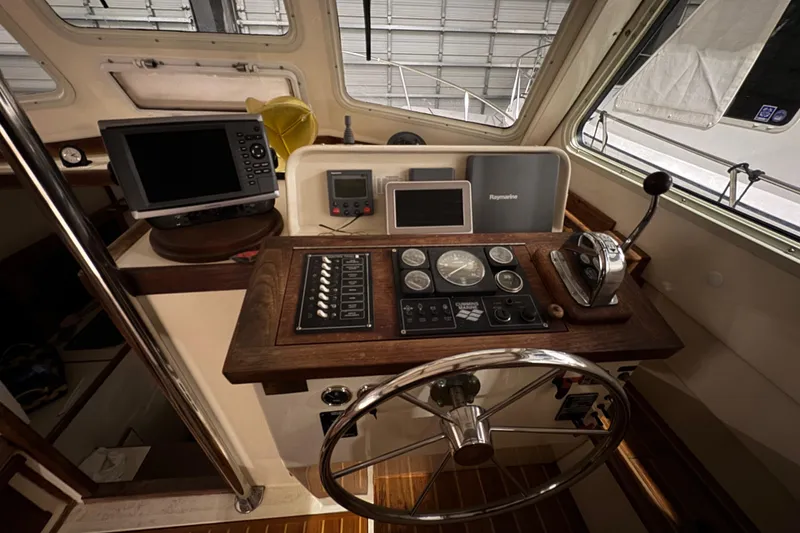 Slide: The Image of Helm of 1988 Blue Seas 31 boat with navigation equipment and wooden steering wheel. - 12