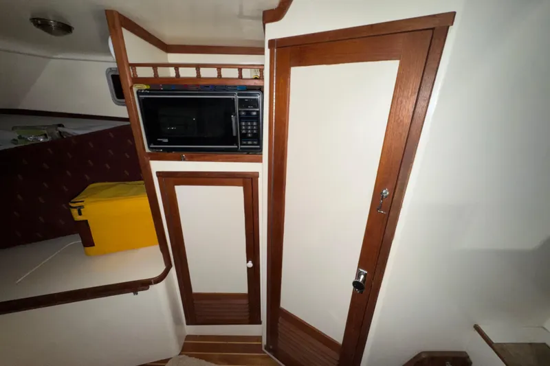Slide: The Image of Interior of 1988 Blue Seas 31 boat with microwave and wooden cabinetry. - 17