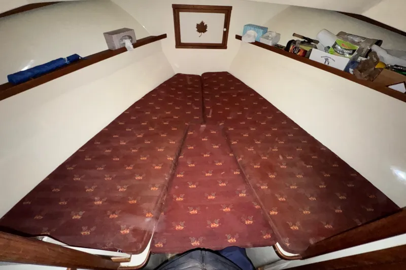 Slide: The Image of Interior cabin of 1988 Blue Seas 31 boat with patterned cushions and storage shelves. - 18