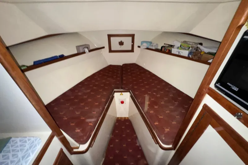 Slide: The Image of 1988 Blue Seas 31 boat interior with red patterned cushions and wooden trim. - 19