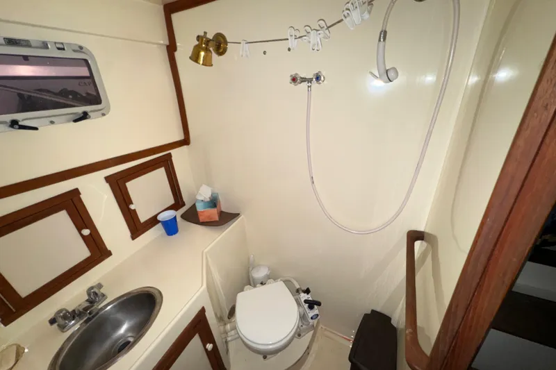 Slide: The Image of 1988 Blue Seas 31 boat bathroom with sink, toilet, and showerhead. - 20