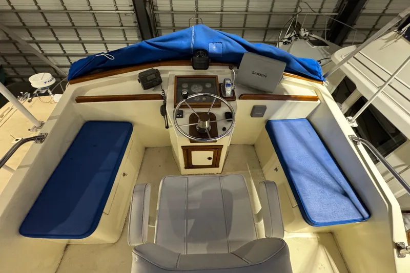 Slide: The Image of 1988 Blue Seas 31 boat cockpit with steering wheel, blue cushions, and navigation equipment. - 22