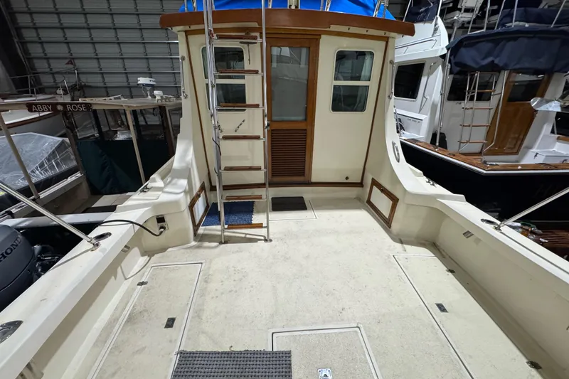Slide: The Image of 1988 Blue Seas 31 boat interior with ladder and wooden door in a marina setting. - 4