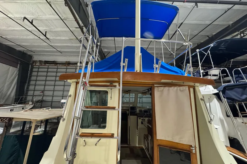 Slide: The Image of 1988 Blue Seas 31 boat with blue canopy, stored indoors. - 6