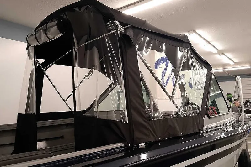 Slide: The Image of 2026 Smoker Craft Phantom 20 X2 boat with protective canopy in a showroom. - 11